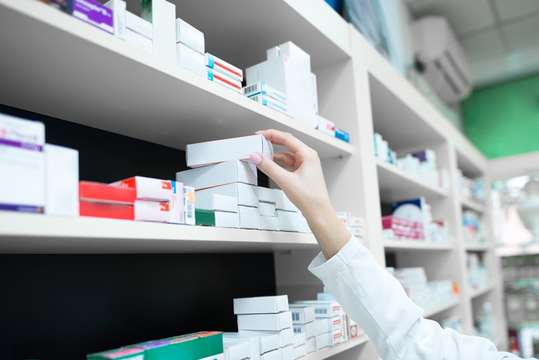 Pharmacist grabbing medication from a shelf