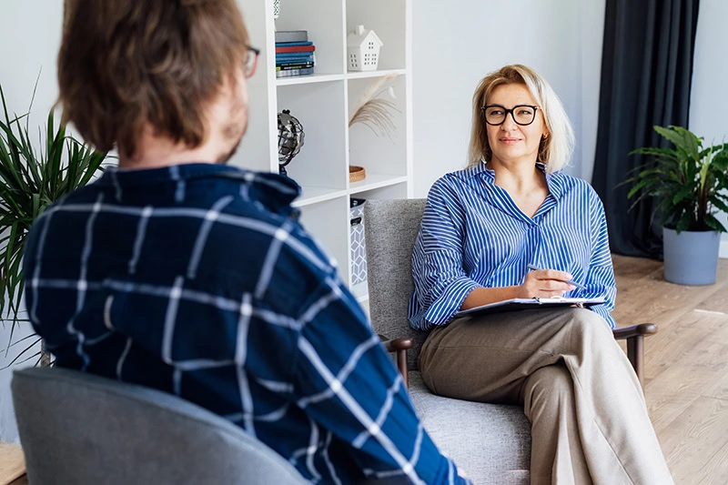 A person talks to a provider about medication-assisted treatment in outpatient rehab.